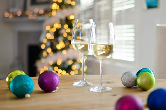 Two glasses of wine on a table with holiday tree decorations
